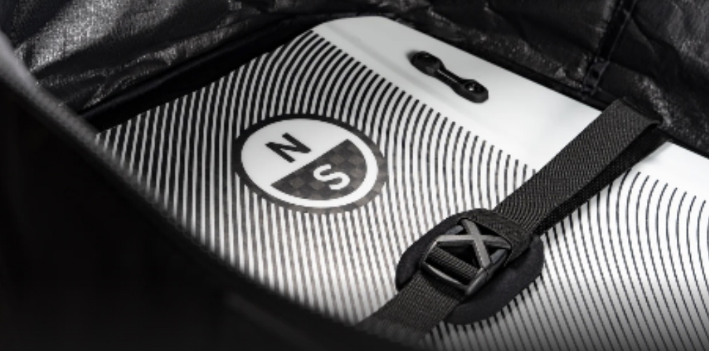 Weißes Board mit rundem Logo, im Inneren der Tasche von einem gepolsterten Gurt gehalten