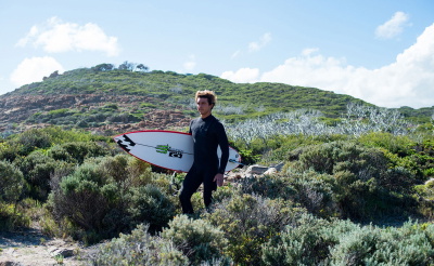 Surfer in einem Eco-Neoprenanzug aus neoprenfreien, recycelten Materialien