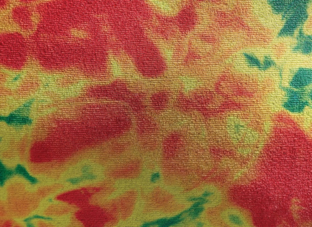 Close-up of mottled red, yellow and green thermal lining fabric resembling a heat map