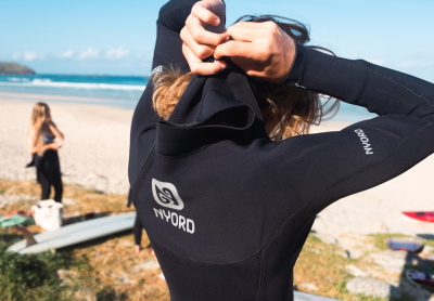 surfeur enfilant une combinaison à zip poitrine