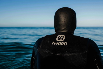 Surfer in einem Nyord Neoprenanzug am Strand
