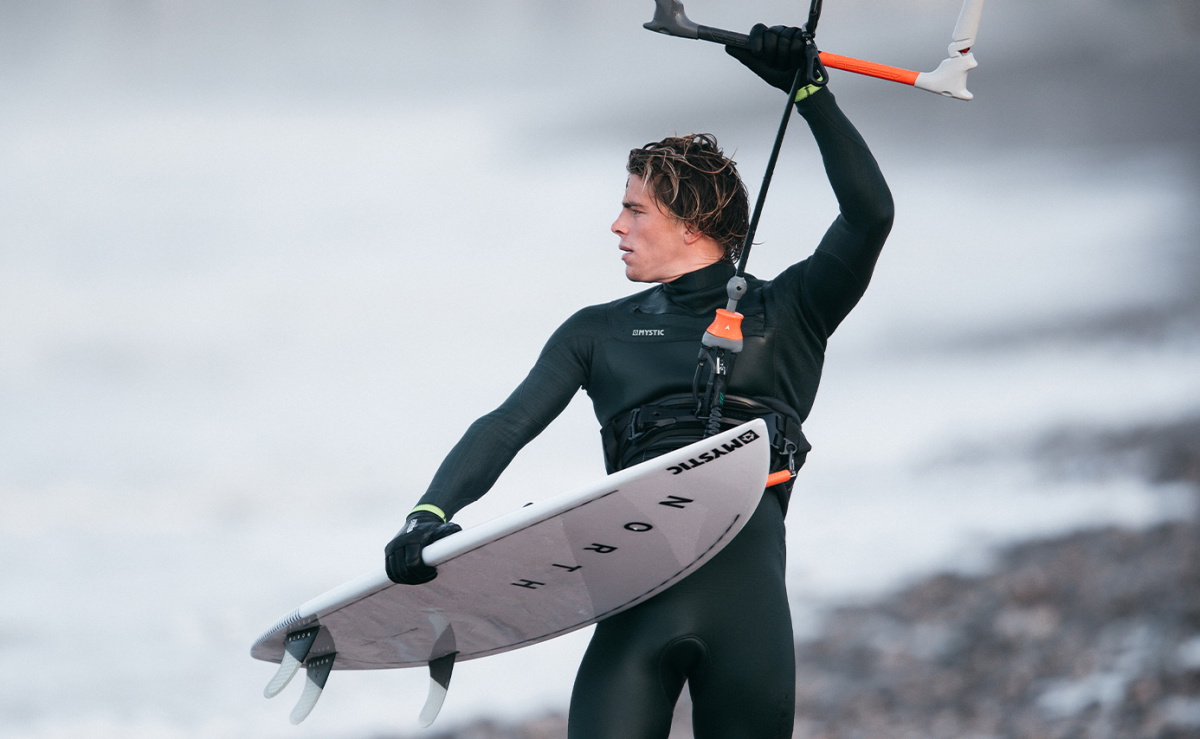 Mystic team riders in their Winter 20/21 wetsuits on the beach