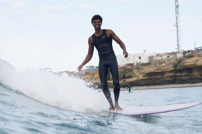 Surferin im ärmellosen Nyord Solu Long Jane Neoprenanzug am Sommerstrand