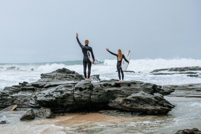 Surfer im Rip Curl Trad Neoprenanzug trägt sein Board ins Wasser